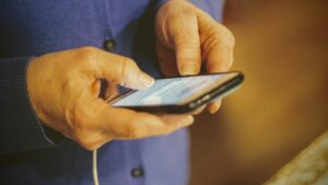 Handen van een persoon die een anonieme sms typt op een smartphone